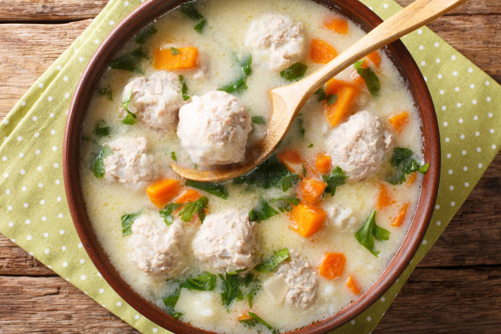 Traditional soup with meatballs, yogurt and vegetables close-up