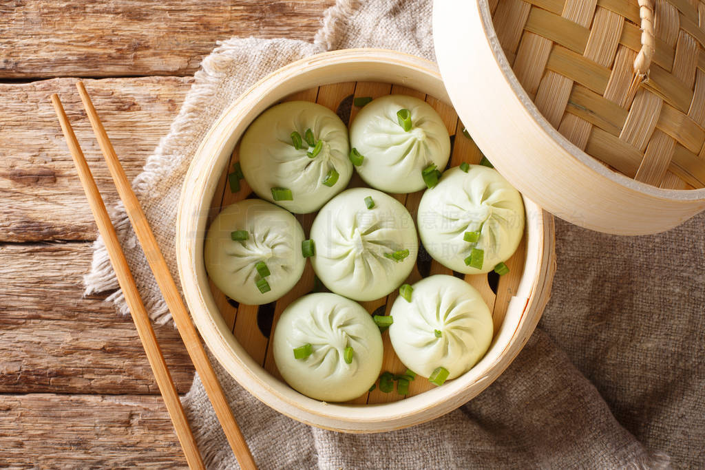 Traditional chinese baozi steam buns in a bamboo steamer basket