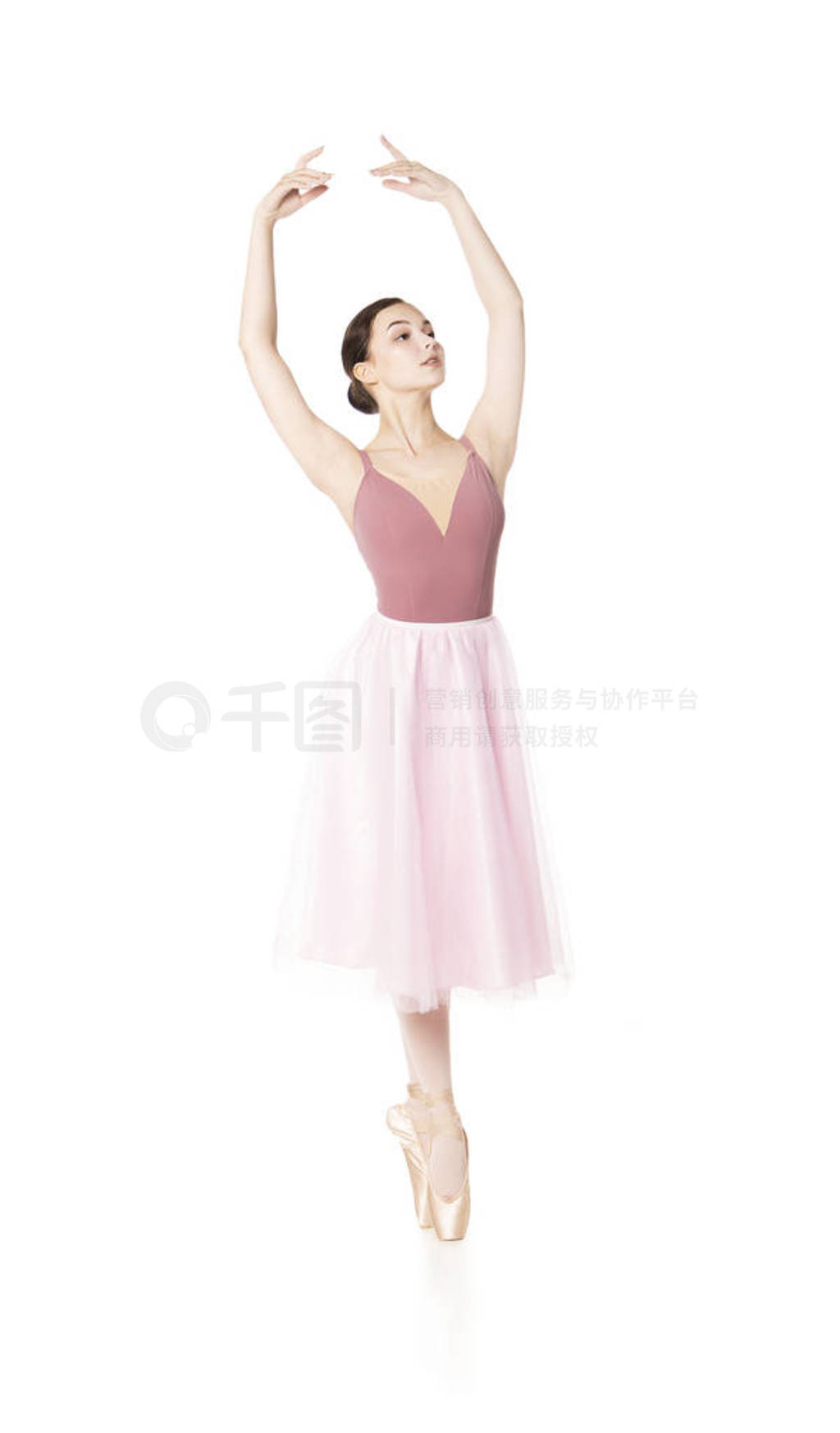 Elegant girl in a pink skirt and beige top dancing ballet.