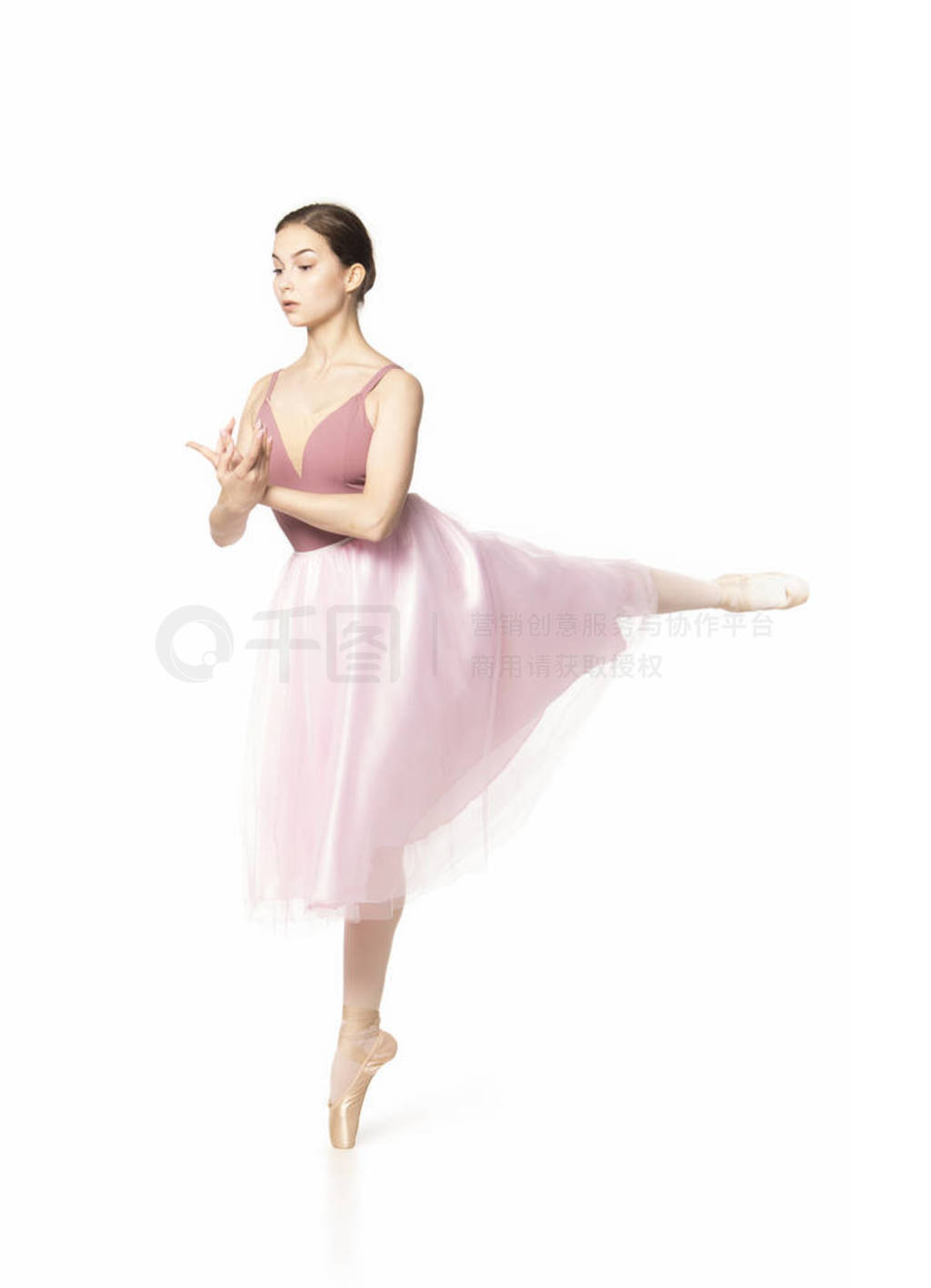 Elegant girl in a pink skirt and beige top dancing ballet.