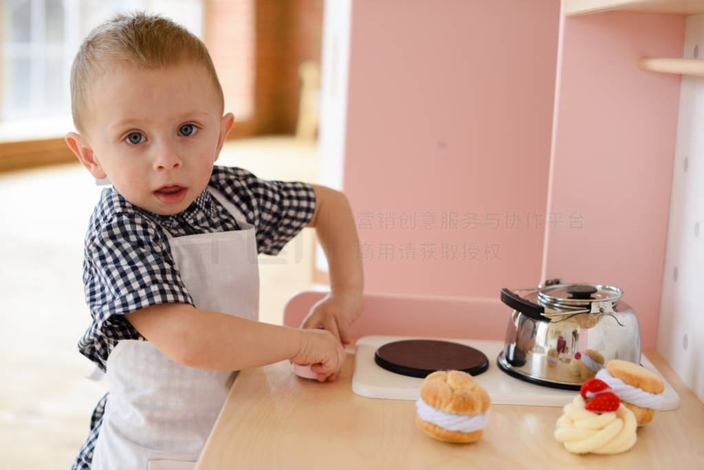 Child playing chef concept. Serious little boy in apron playing