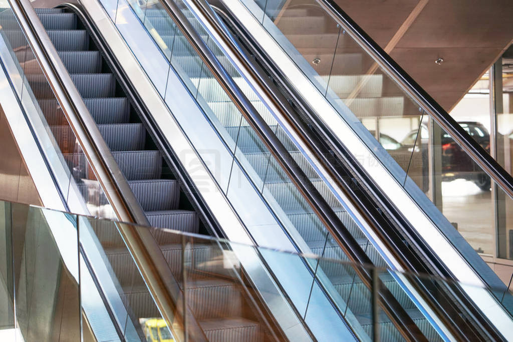 Empty escalator inside a glass building.