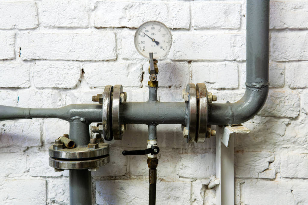 heating pipe with pressure gauge, valve and fittings, against a