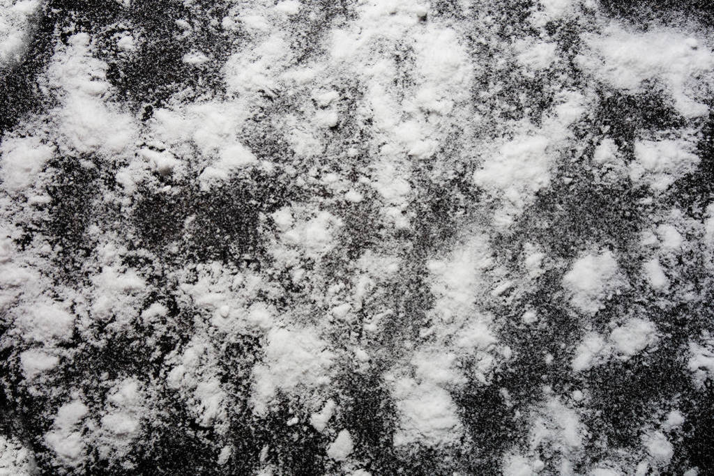 White powder on black background. Isolated abstract pattern for