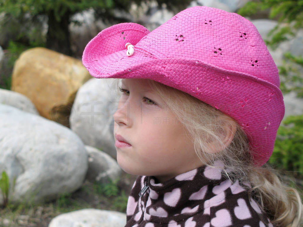 Close-up of the face of a contemplative little girl in a cowboy