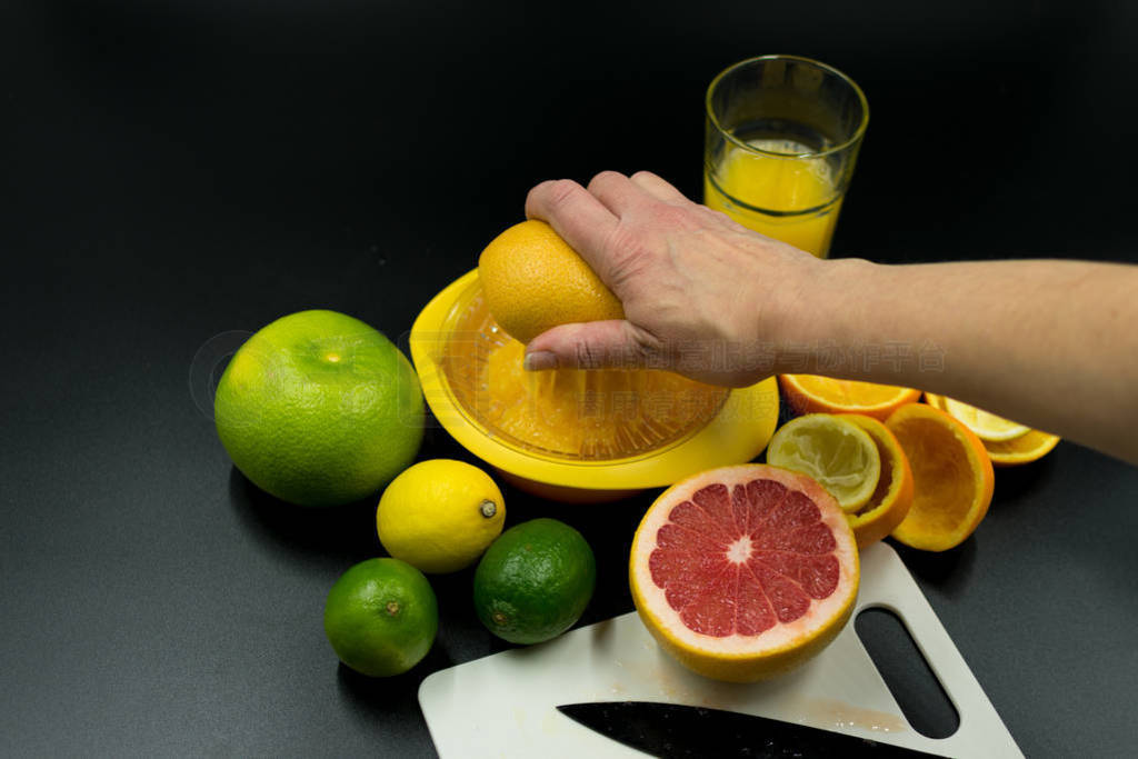 Hand squeezes grapefruit in juicer.