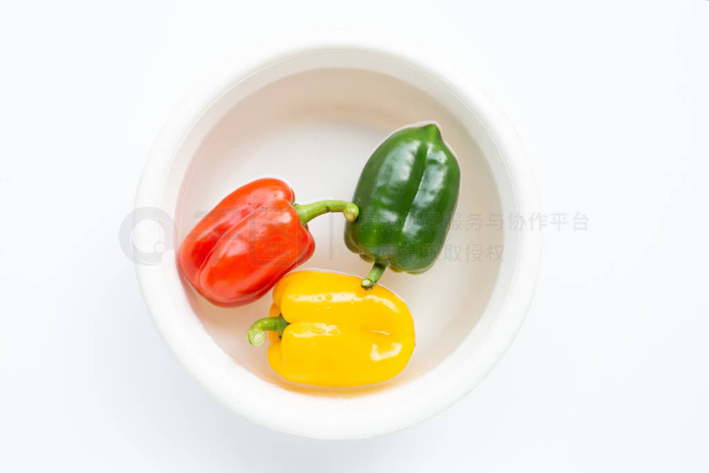 Bell pepper soaked in water. Washing fresh vegetables on white