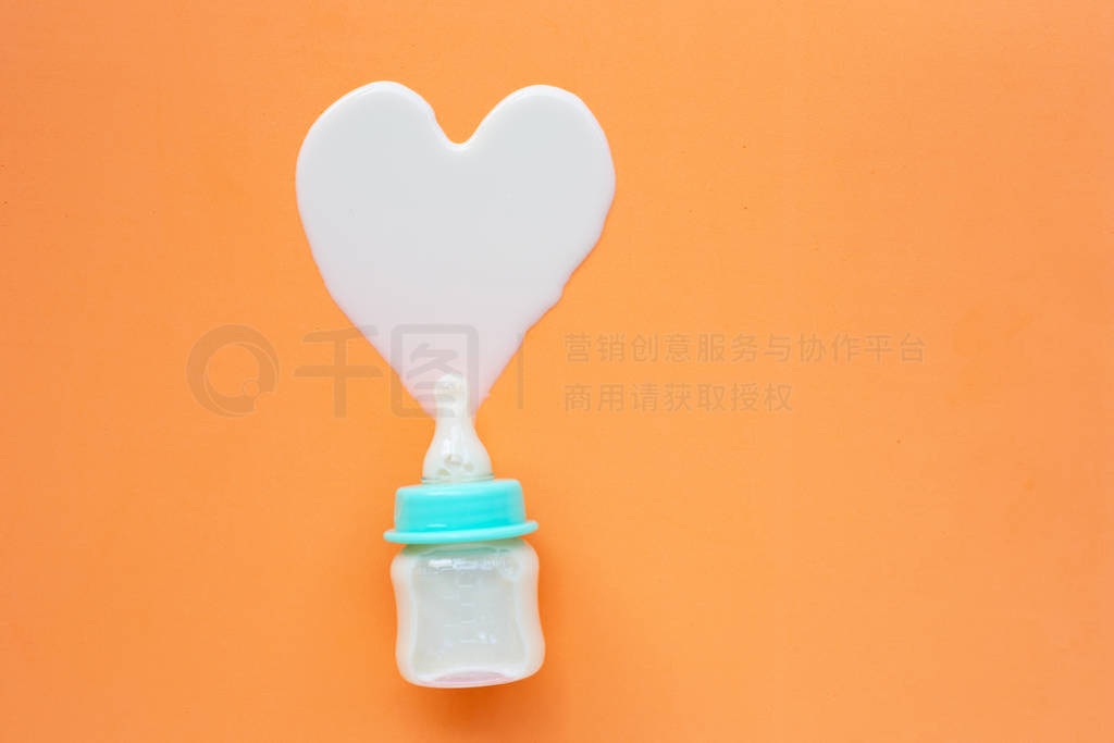 Bottle of milk for baby on orange background.