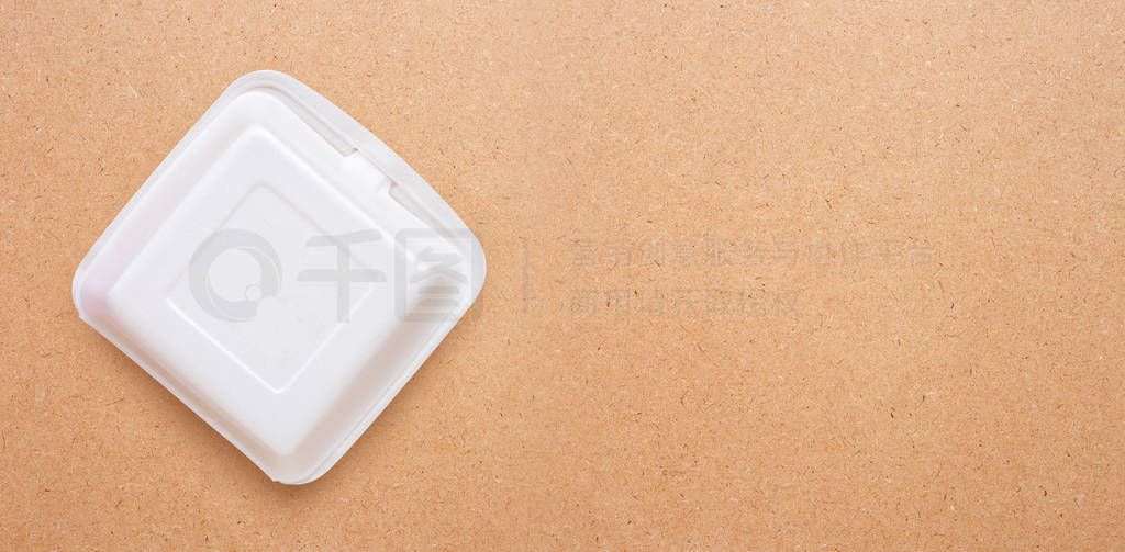 Foam food container on plywood background.