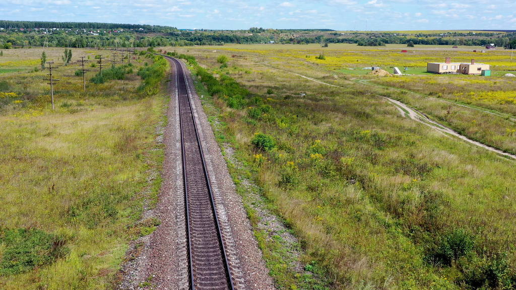 Empty straight single-way railways at summer sunny day.
