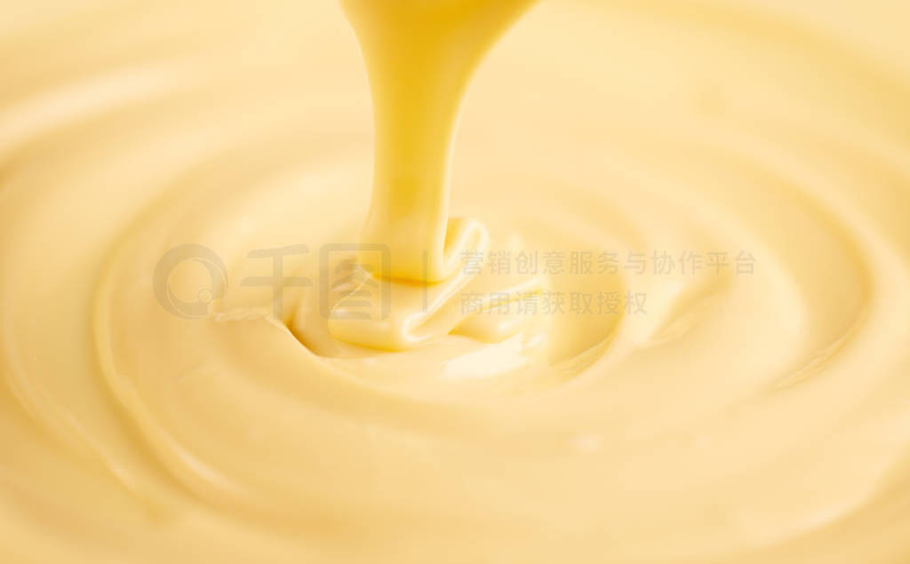 White chocolate. Pouring melted liquid white chocolate. Closeup