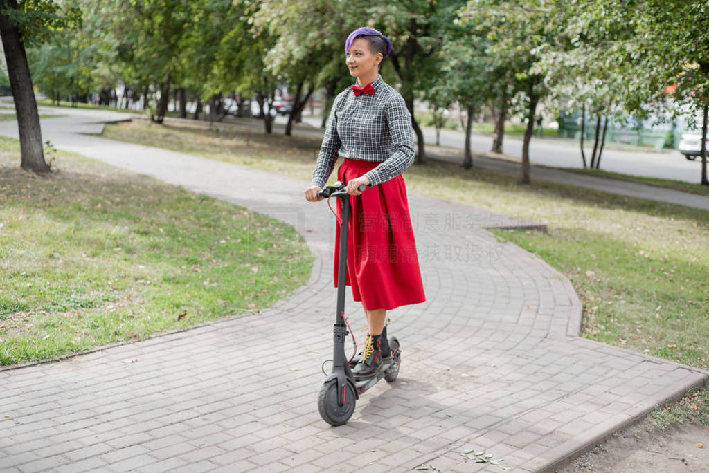 A young woman with purple hair rides an electric scooter in a pa