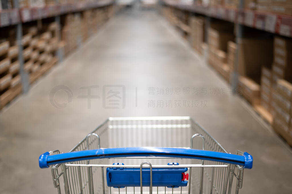 Empty shopping cart in a furniture store warehouse. Supermarket