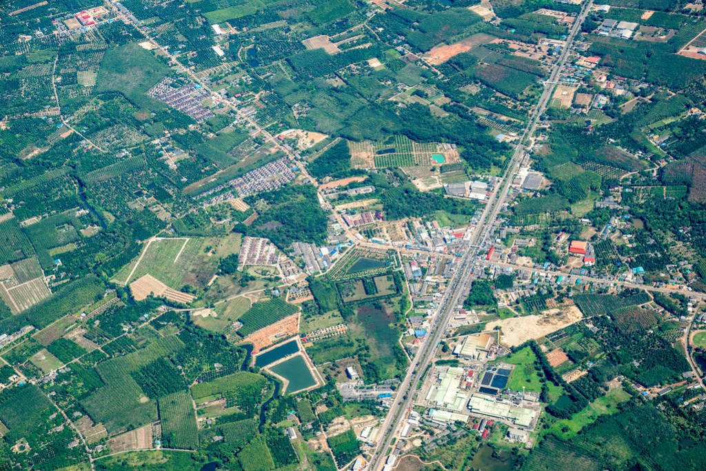 the view of green field and farm and city downtown in middle of