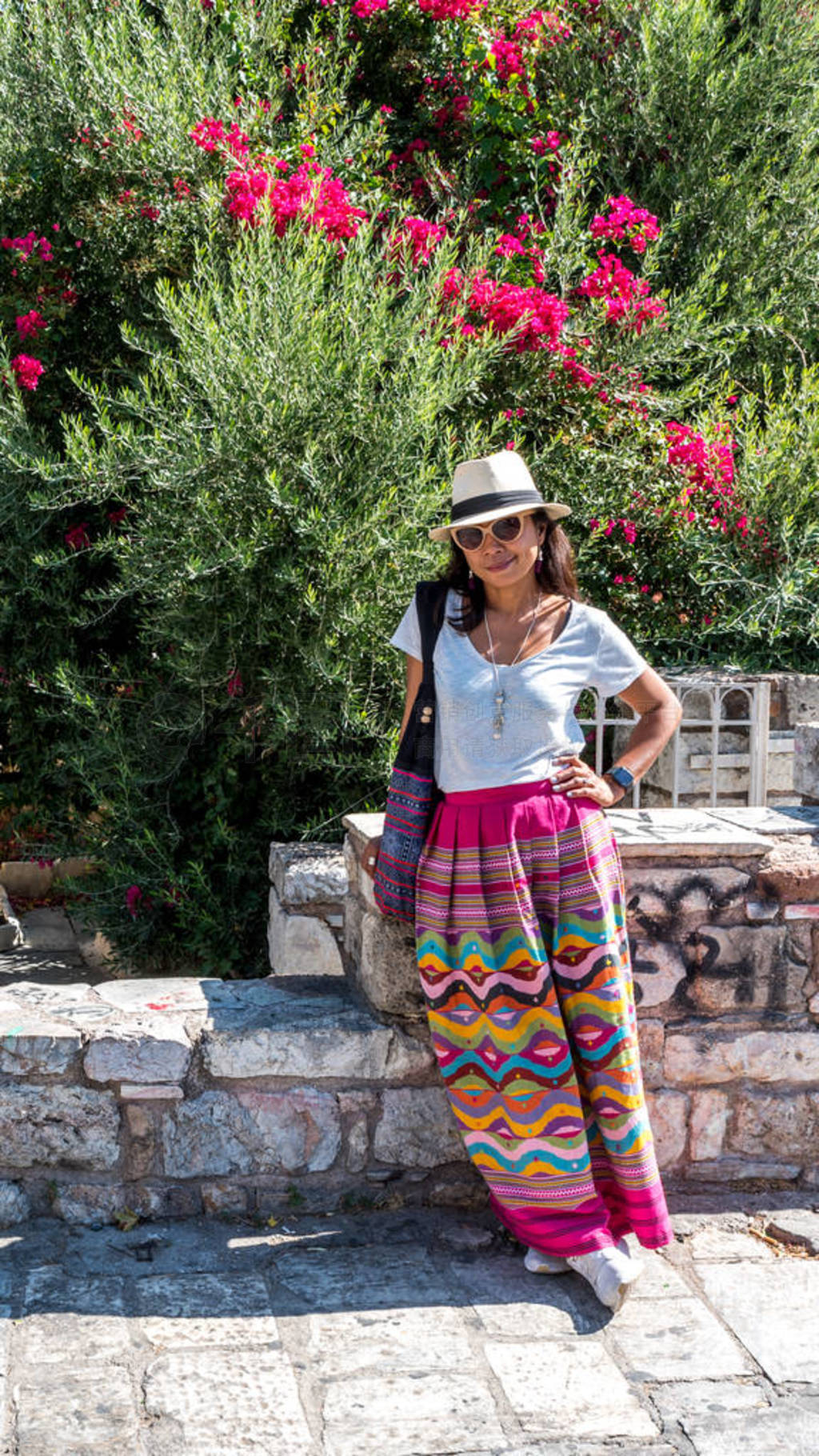 Asian woman in white t-shirt in Athens in white hat and sarong