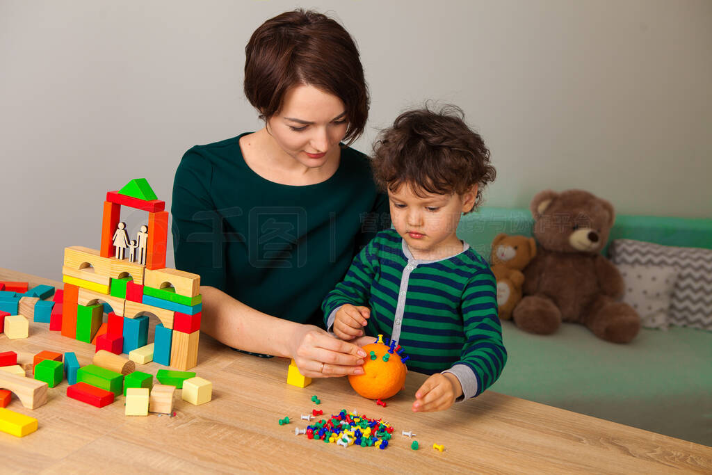 Mom shows her son on the example of figures of a family and a h
