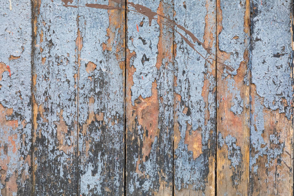Wooden background of old grey-painted boards. The paint cracked