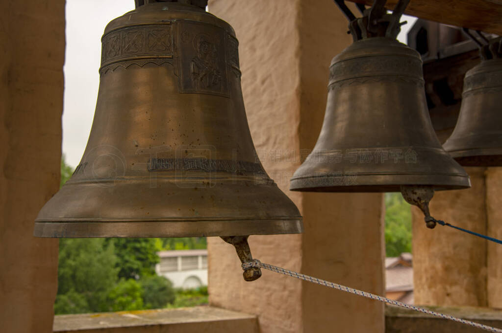 Bells of various sizes hang from a thick wooden beam.