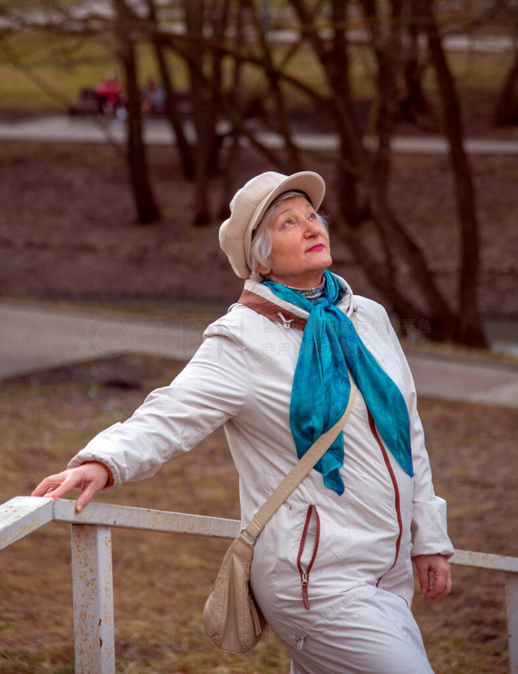 An elderly elegant woman in a beret on a walk in the Park.