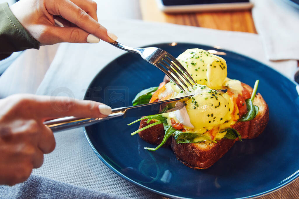 Benedict with pickled salmon and spinach on a blue plate