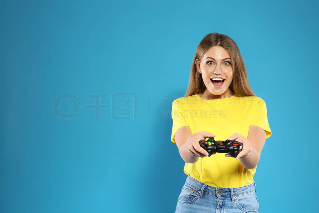 Emotional young woman playing video games with controller on col