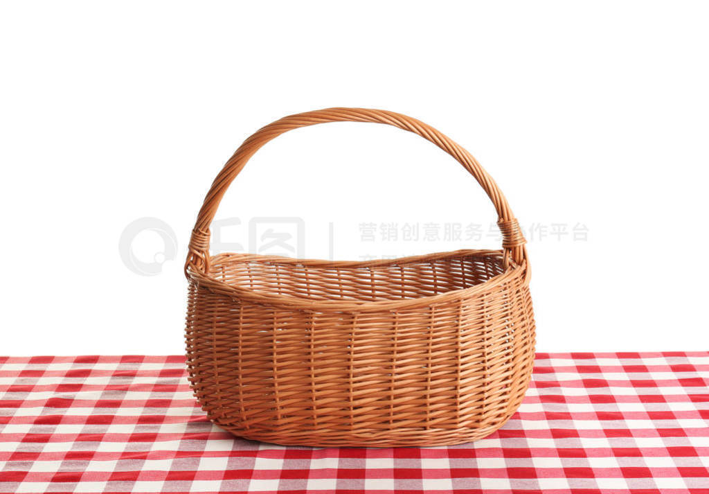 Empty picnic basket on checkered tablecloth against white backgr