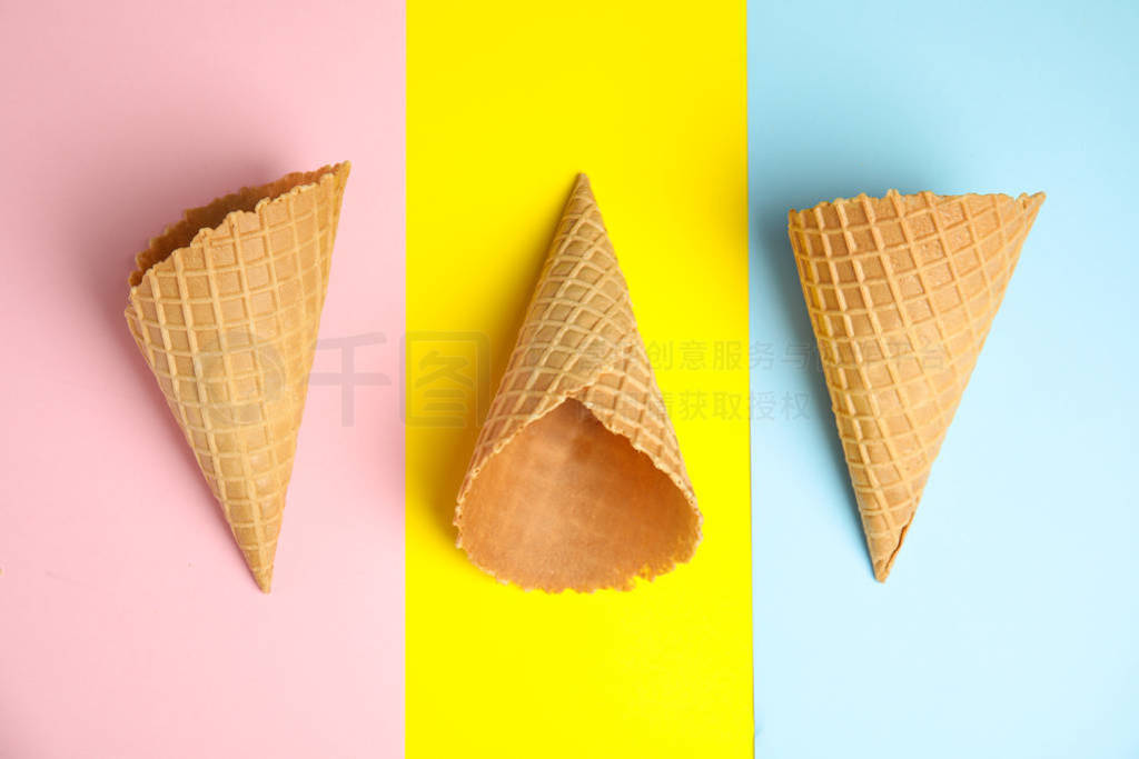 Empty wafer ice cream cones on color background, flat lay