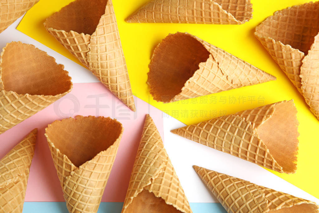 Empty wafer ice cream cones on color background, flat lay