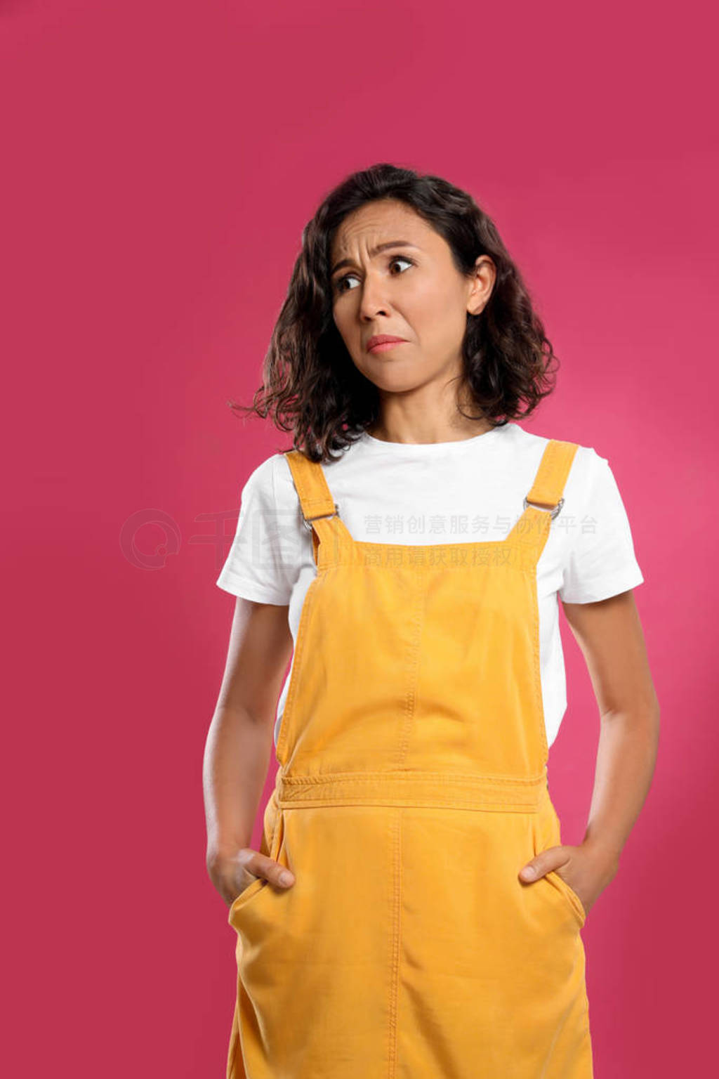 Emotional young woman in casual outfit on pink background