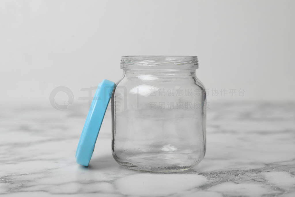 Empty glass jar on white marble table