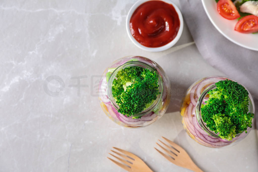 Healthy salad in glass jars on light table, flat lay. Space for