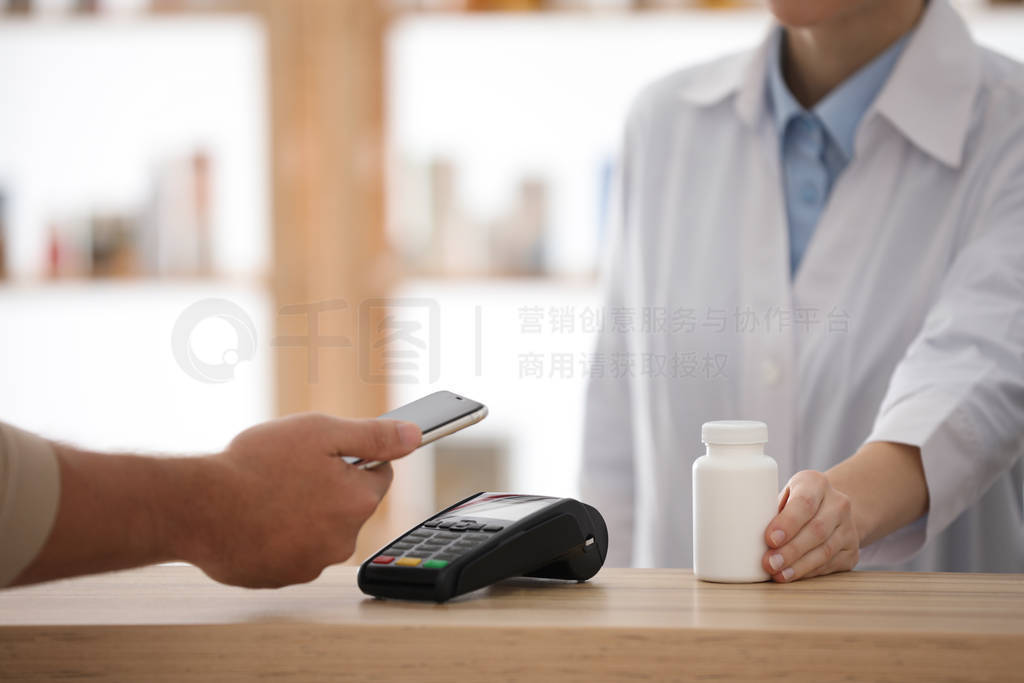 Customer using terminal for contactless payment with smartphone