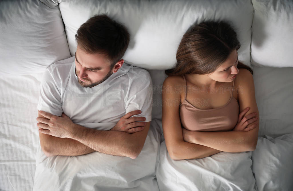 Unhappy couple with relationship problems after quarrel in bed,