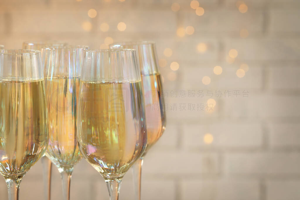 Glasses of champagne against blurred lights, closeup. Space for