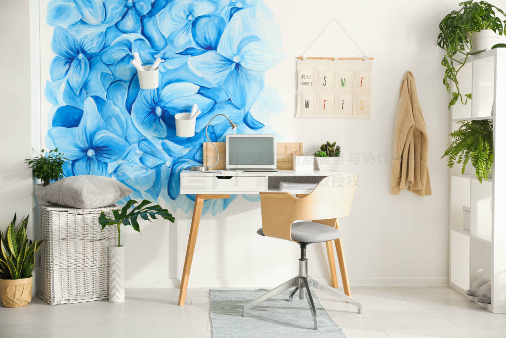 Stylish living room interior with blue flowers painted on wall.