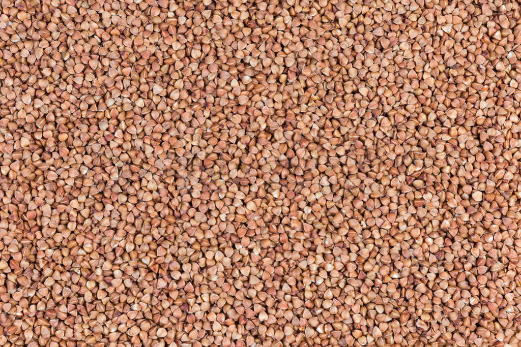 Background of uncooked pre-steamed buckwheat groats