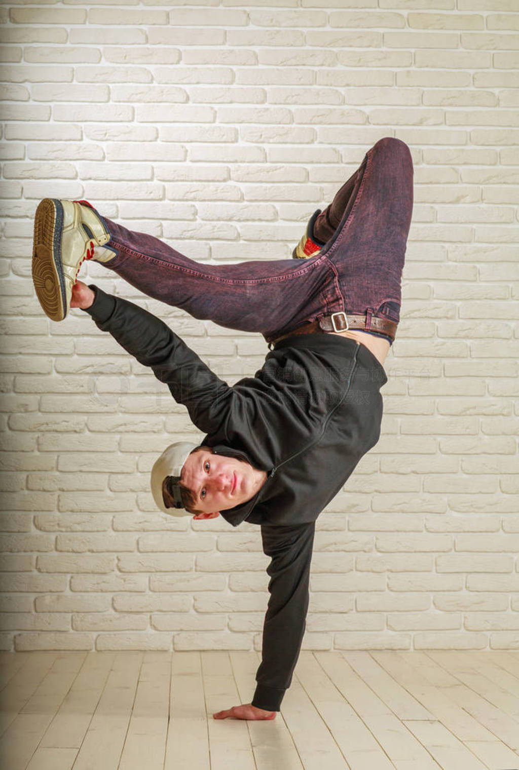 Young guy in street clothes style dancing hip-hop and breykdans