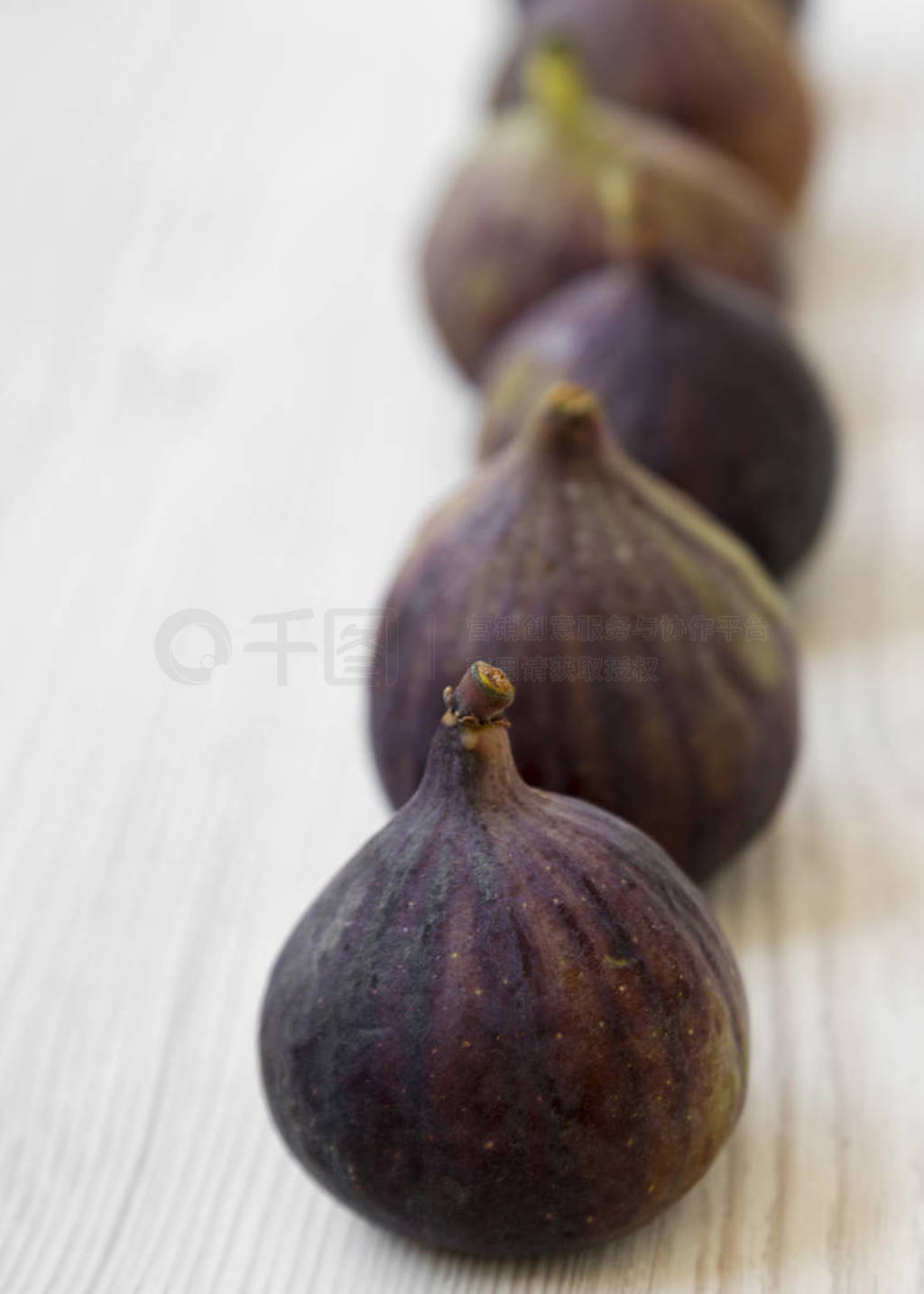 Fresh figs on a white wooden surface, low angle view. Selective