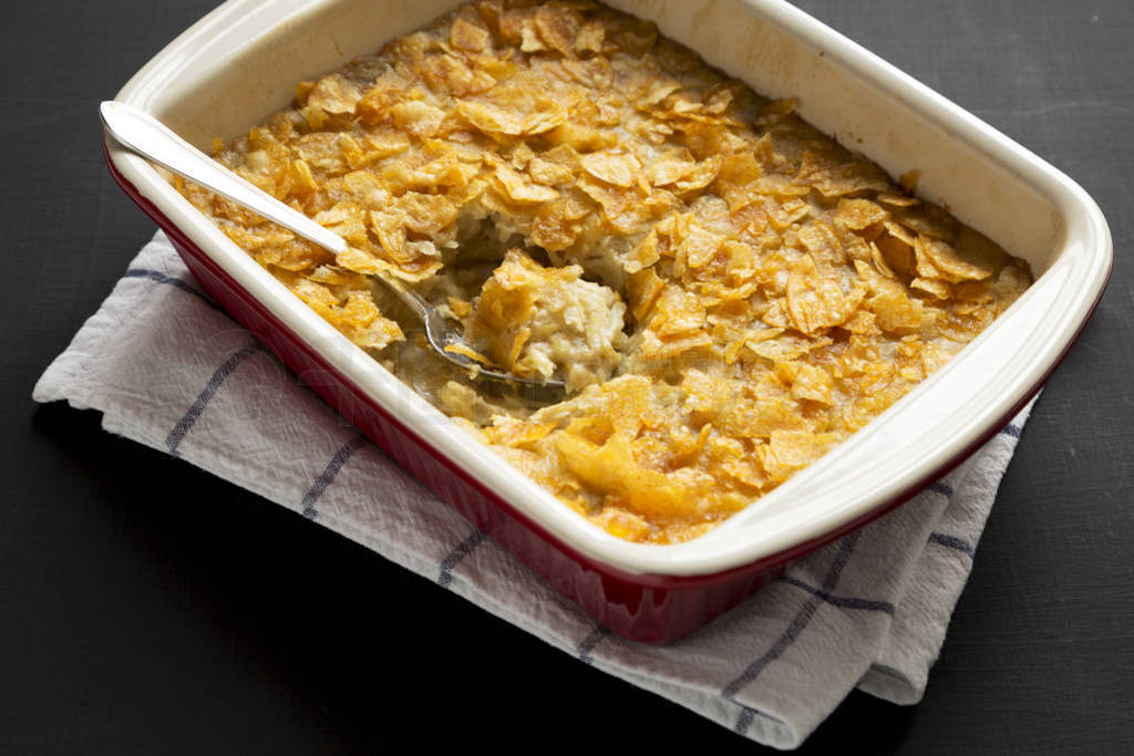 Cheesy Homemade Funeral Potatoes Casserole in a dish over black