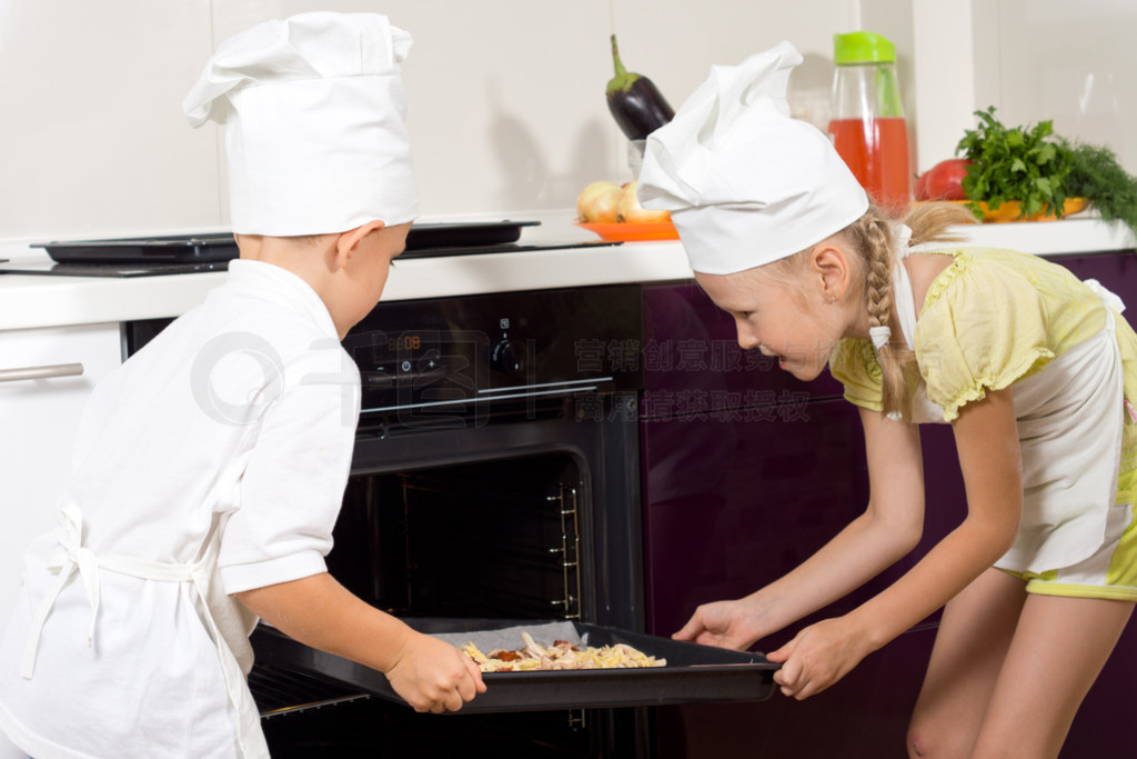 deux jeunes enfants fiers mettre la pizza dans le fourĺӣѱ