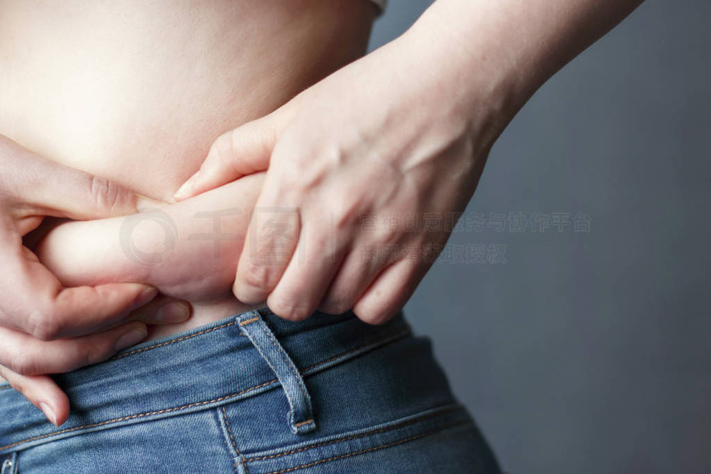 woman's hand holding excessive belly fat, the concept of weight
