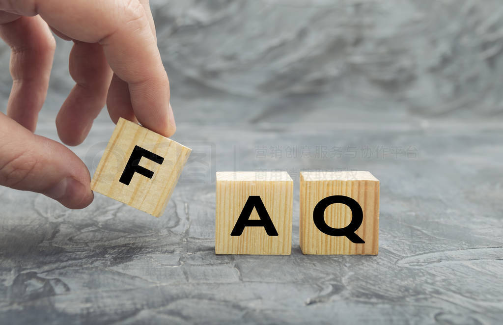 Hand putting wooden cube block with word FAQ (frequently asked