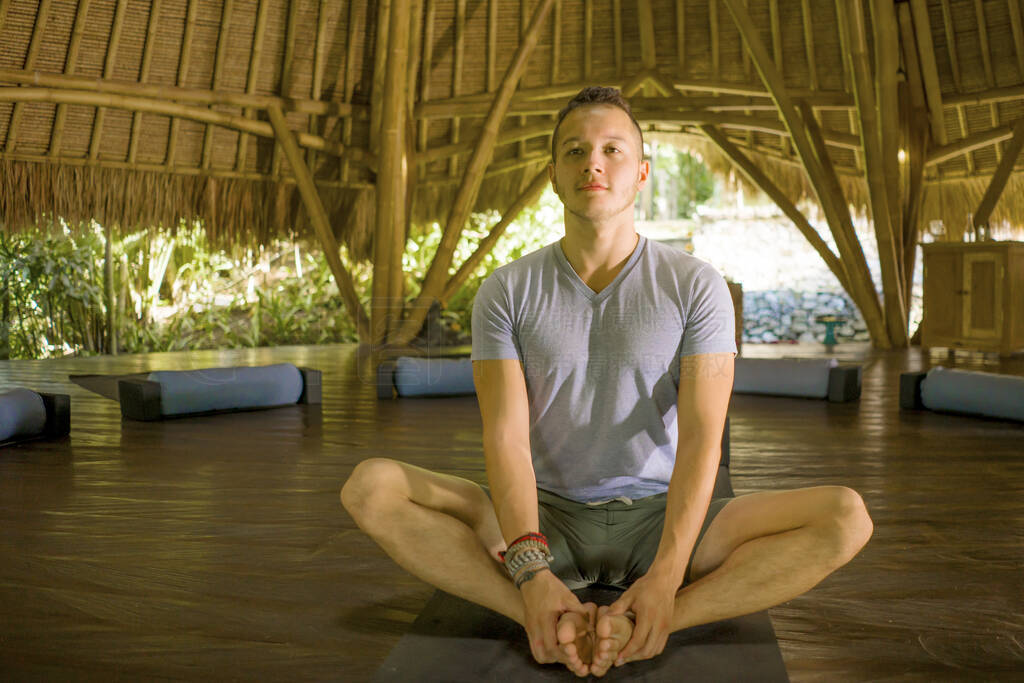 young attractive and happy man doing yoga sitting in lotus posit