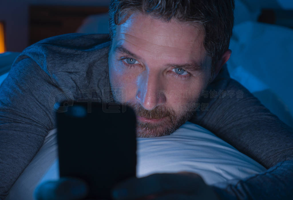 young attractive and relaxed man with blue eyes lying on bed lat