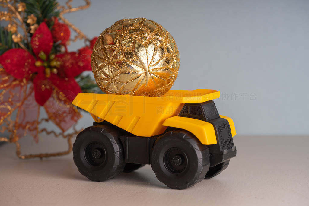 Yellow dump truck model with Christmas tree toy. Garland lights