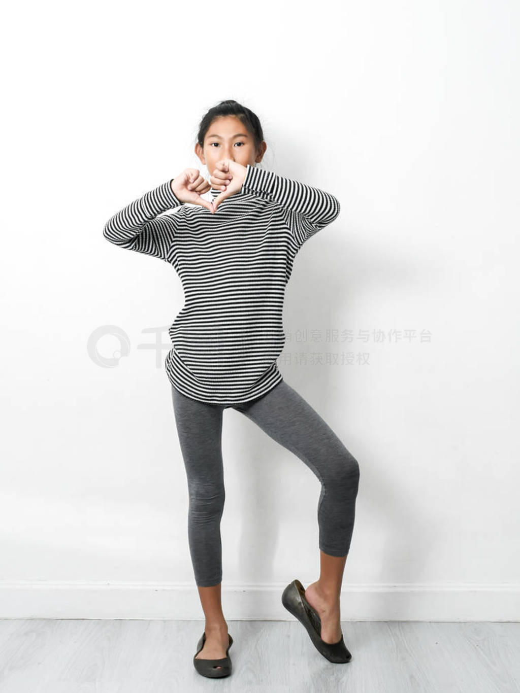 Asian girl wearing turtle neck, skinny dancing with white wall,