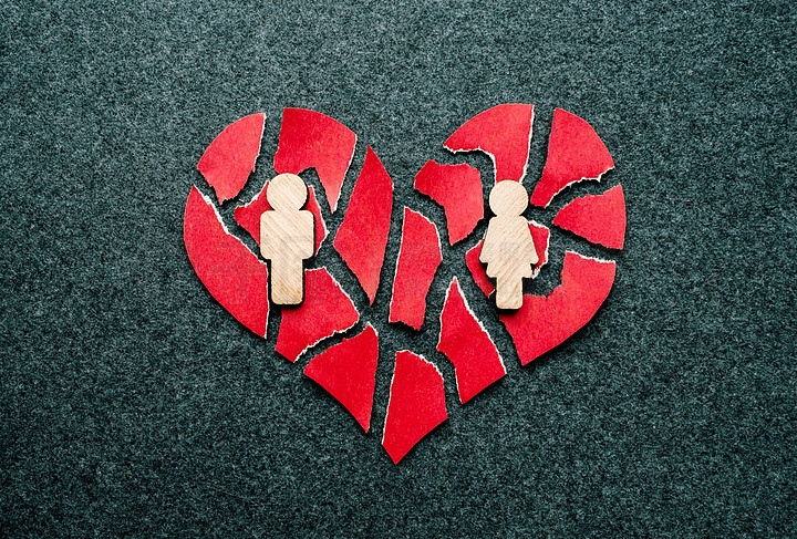 纸红色破碎的心与男人和女人的木图在黑暗的感觉背景