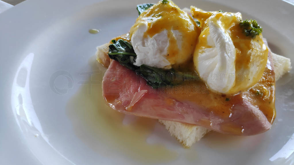 Eggs Benedict and toasted bread with spinach