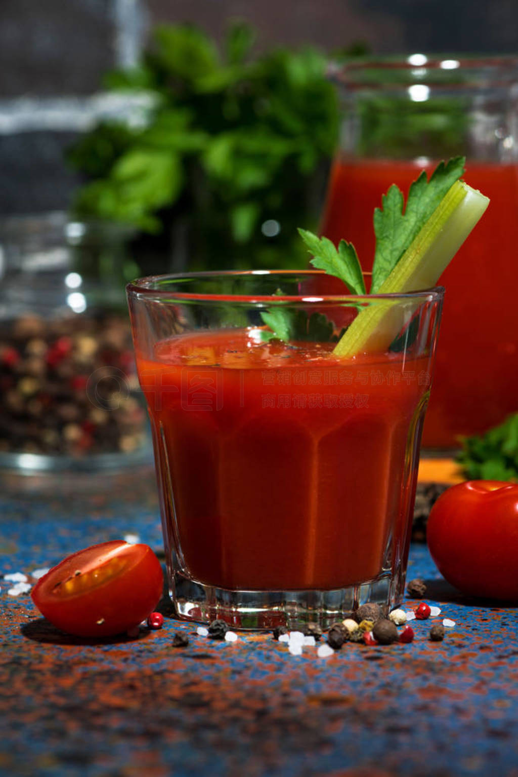 fresh tomato juice with salt and celery on dark table, vertical