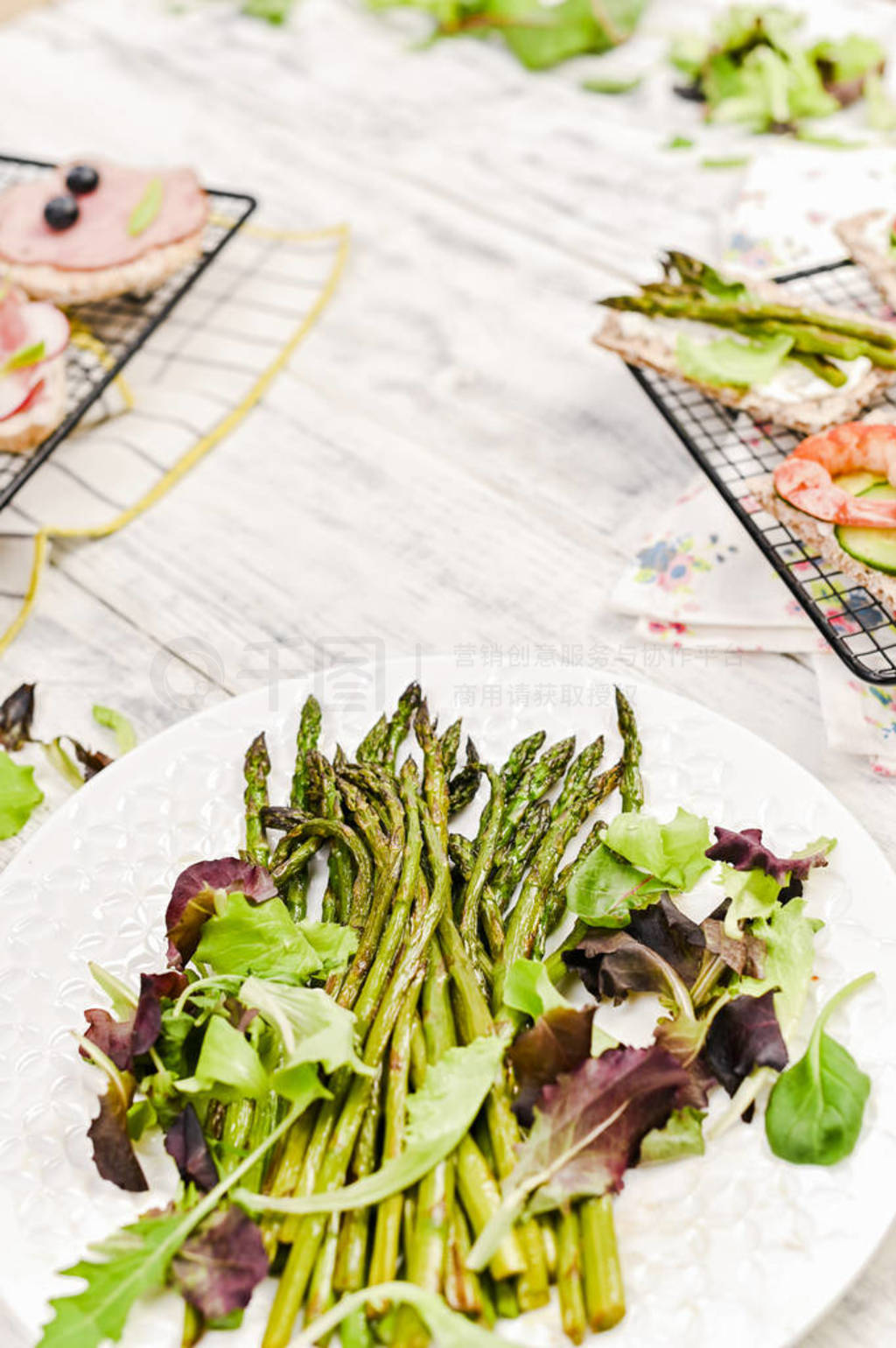 Summer snack sandwiches and asparagus, on a white wooden table.